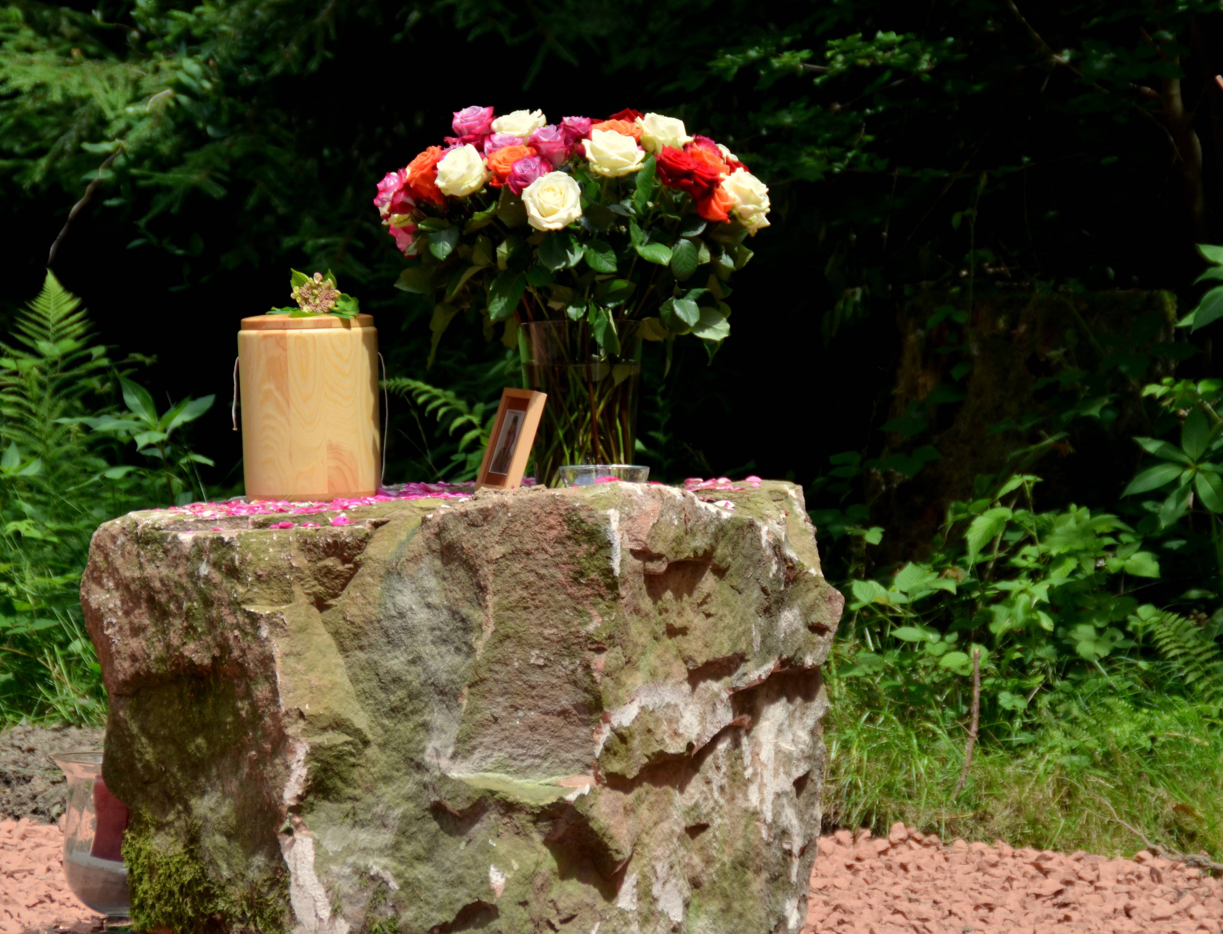  Großer Sandstein auf Andachtsplatz mit Urne und einem Rosenstrauß 